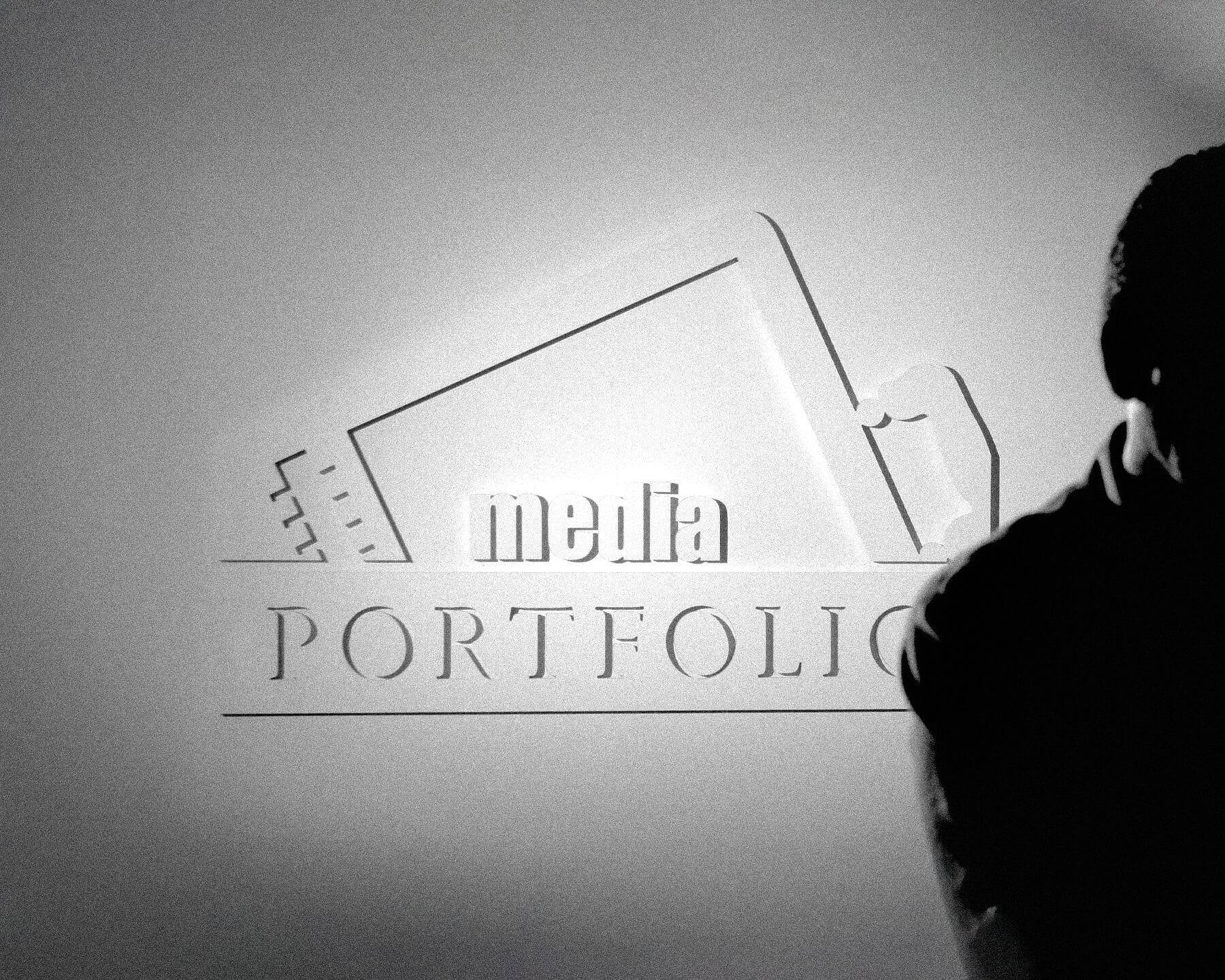 Early Media Portfolio logo on wall lit by stark lighting. Rick is silhouetted in the foreground.